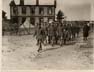 French soldiers (medics?) marching in front of a stockade